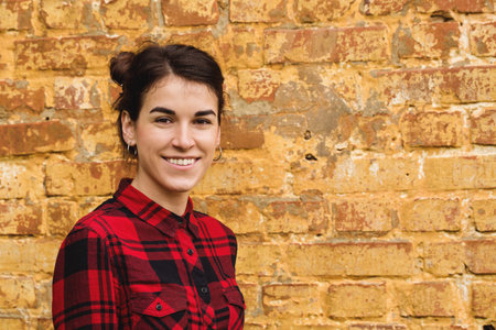 Portrait of a young dark-haired girl against the background of a brick wall