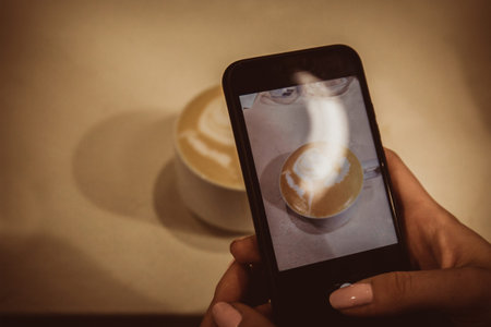 Barista conducts a trainee masterclass, teaches work. Trainee takes pictures