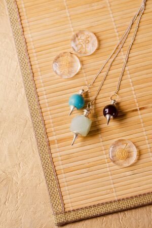 Pendulums for working in a reiki stream and signs of the second stage of a reiki on rock crystalの写真素材