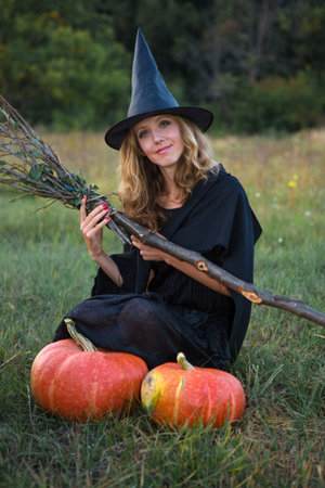 Witch in a field with a broom preparing for the Sabbath