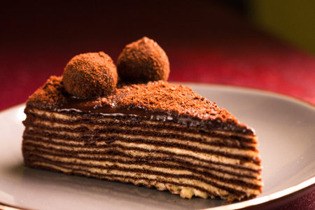 Spartak multilayer chocolate cake on a burgundy background