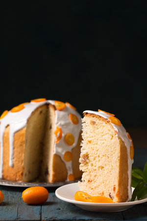 Still life with Easter cake and juicy kumquats on a wooden background