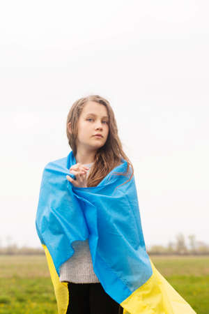 The little girl threw a yellow and blue flag of Ukraine on her shouldersの写真素材