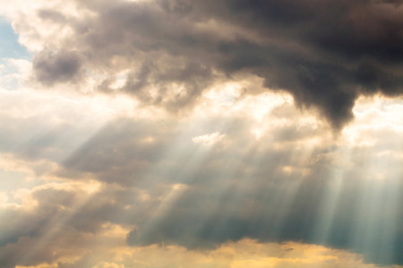 Beautiful sunbeams shine through the storm cloudsの写真素材