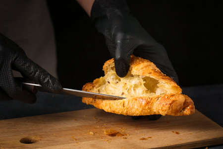The chef prepares the croissant with the filling