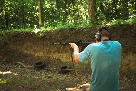 A Ukrainian civilian man is training to shoot an Akm machine gun during Ukraine's war with Russia