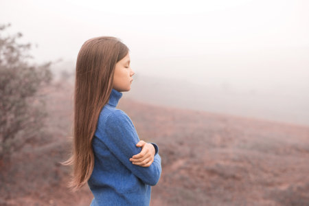 A beautiful young girl was alone in nature in a foggy morningの写真素材