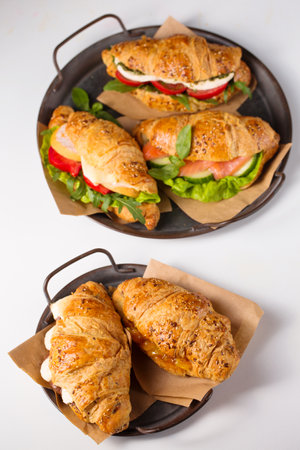 Croissants with various sweet and salty fillings on traysの写真素材
