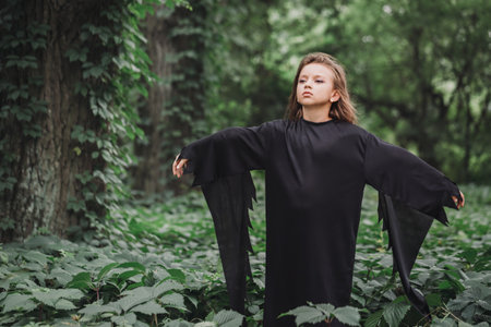 Portrait of a charming young witch in the forest. Halloween conceptの写真素材
