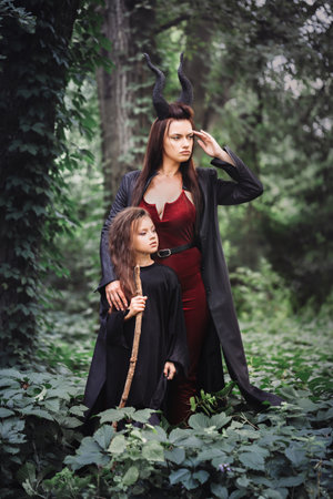 Horned witch with a girl in a dark forest. Halloween conceptの写真素材