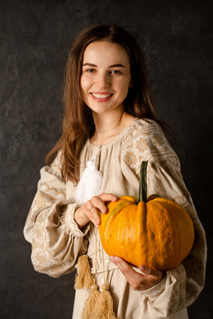 A young girl in a Ukrainian dress holds a pumpkin in her hands, a symbol of rejection of a suitorの写真素材
