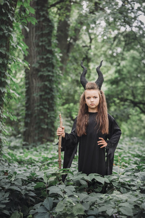 Little magical witch with big horns Maleficent in the forest. Halloween conceptの写真素材
