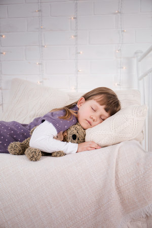The girl lies on a vintage bed with knitted underwear. Christmas conceptの写真素材