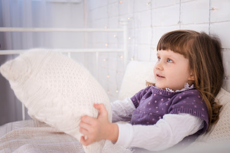 The girl lies on a vintage bed with knitted underwear. Christmas conceptの写真素材
