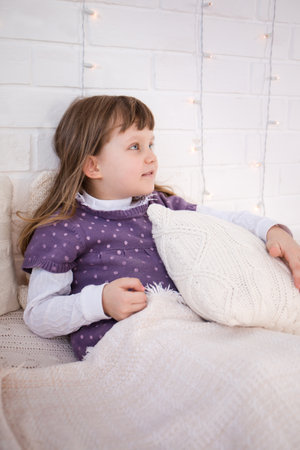 The girl lies on a vintage bed with knitted underwear. Christmas conceptの写真素材