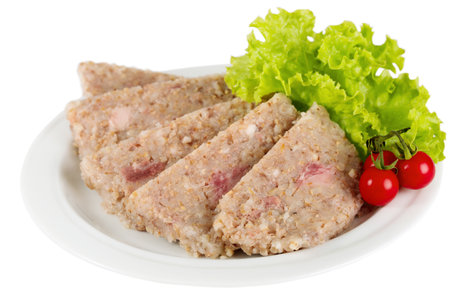Canned barley porridge cut into slices with meat, cherry tomatoes and lettuce on a plate isolated on white backgroundの写真素材