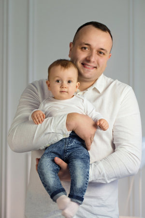 Portrait of a young loving father with a small child in his armsの写真素材