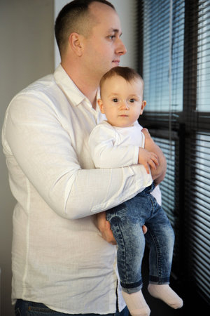 Portrait of a young loving father with a small child in his armsの写真素材