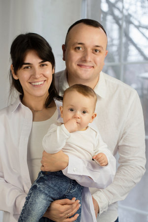 Portrait of young happy parents with a small childの写真素材