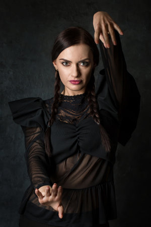 Dancing woman with pigtails in a gothic style on a dark backgroundの写真素材