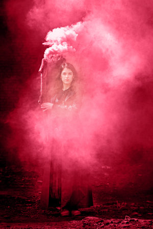 Beautiful witch in black with a smoking stick. halloween conceptの写真素材