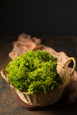 Fresh juicy curly lettuce in basket, photo in rustic style, close-upの写真素材