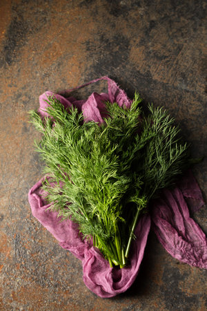 A bunch of fresh dill on purple cheesecloth on a metallic backgroundの写真素材