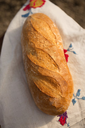 Homemade bread on an embroidered Ukrainian towel, cooling in the outdoorsの写真素材