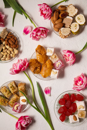 Still life of oriental sweets on a light background with pink tulipsの写真素材