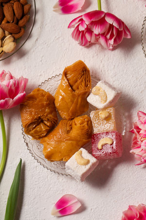 Still life of oriental sweets on a light background with pink tulipsの写真素材