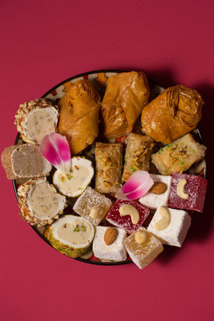 Still life of oriental sweets on a pink background with pink tulipの写真素材