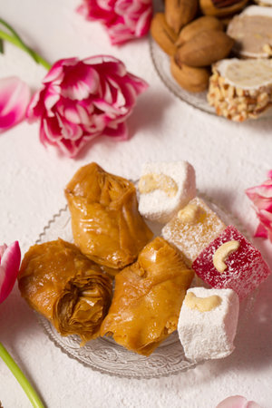 Still life of oriental sweets on a light background with pink tulipsの写真素材