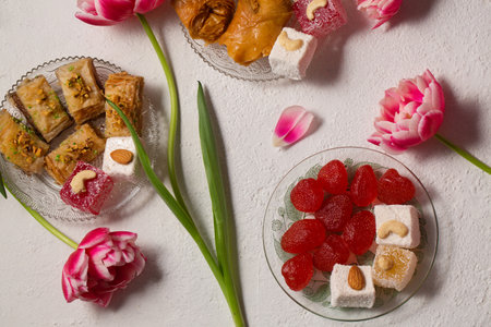 Still life of oriental sweets on a light background with pink tulipsの写真素材