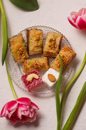 Still life of oriental sweets on a light background with pink tulipsの写真素材
