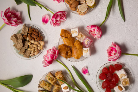 Still life of oriental sweets on a light background with pink tulipsの写真素材