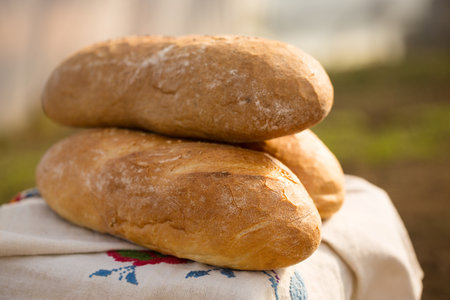 Homemade bread on an embroidered Ukrainian towel, cooling in the outdoorsの写真素材