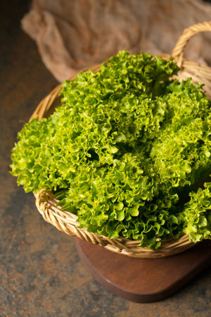 Fresh juicy curly lettuce in basket, photo in rustic style, close-upの写真素材