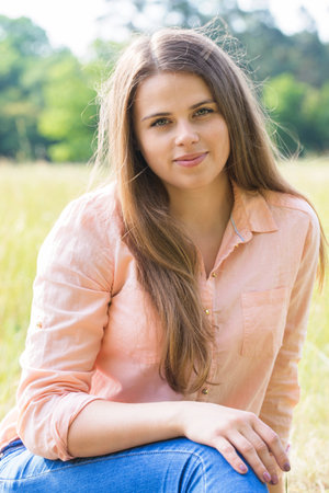 Portrait of a happy young girl in the park on a sunny dayの写真素材
