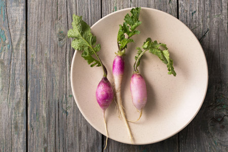 Fresh, white, long radish with leaves on a wooden boardの写真素材