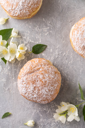 Berliner donuts in powdered sugar with jasmine flowersの写真素材