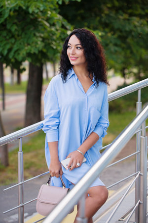 Portrait of a beautiful business woman near the railing on the stairs in the cityscapeの写真素材