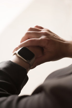 Young office worker looking at smart watch, hands close-upの写真素材