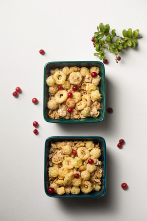 Breakfast cereal with granola and corn rings in small bowls on a white background