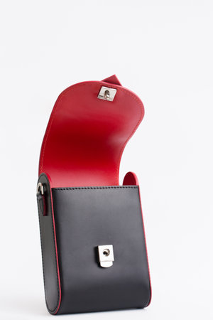 Small elegant black bag with red inserts in the shape of a heart on a white backgroundの写真素材