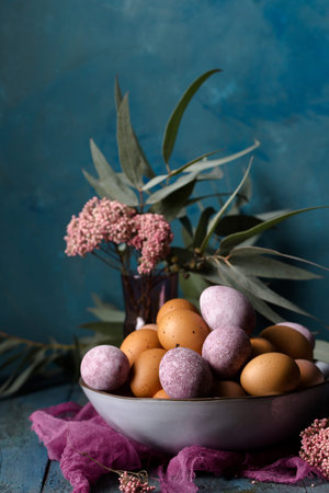 Still life with eggs in a bowl on a blue background, rustic style