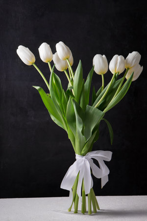 A bouquet of beautiful white tulips on a black backgroundの写真素材
