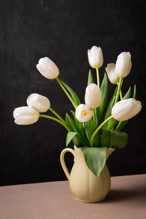 A bouquet of beautiful white tulips in a yellow jugの写真素材
