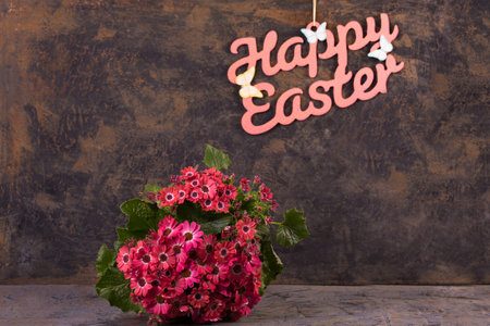 A bouquet of pink spring flowers on a metallic background with an Easter inscription