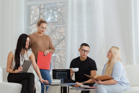 A group of people are sitting on a sofa and discussing work issues.