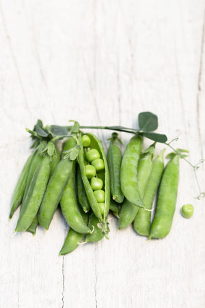 Pods of ripe green peas on a white backgroundの写真素材